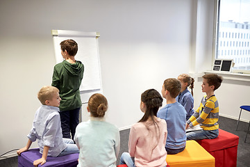 Image showing student boy with marker writing on flip board