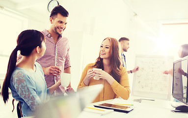 Image showing happy creative team drinking coffee at office