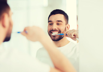 Image showing man with toothbrush cleaning teeth at bathroom