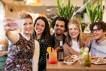 Image showing friends taking selfie by smartphone at bar or cafe