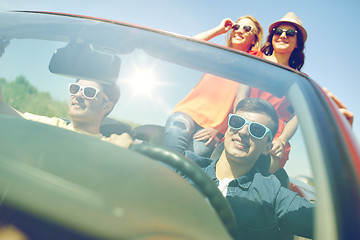 Image showing happy friends driving in cabriolet car