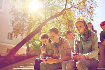 Image showing group of teenage friends with smartphones outdoors