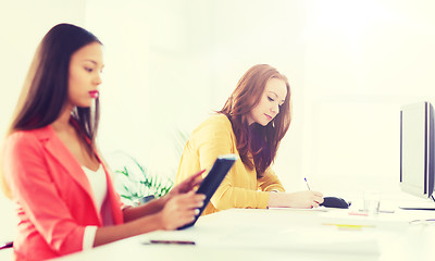 Image showing creative female office worker writing to notebook