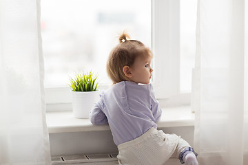 Image showing lovely little girl at home window