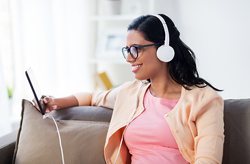 Image showing happy woman with tablet pc and headphones at home