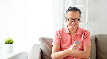 Image showing man with smartphone and headphones at home