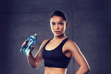 Image showing woman drinking water from bottle in gym