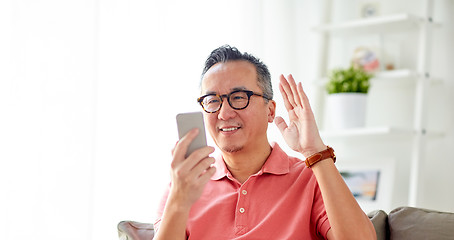 Image showing happy man having video call on smartphone at home