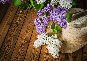 Image showing Still-life with a bouquet of lilacs and a straw hat, close-up