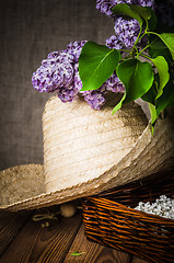 Image showing Still-life with a bouquet of lilacs and a straw hat, close-up