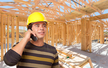 Image showing Hispanic Contractor Using Phone On Site Inside New Home Construc