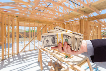 Image showing Hand With Stacks of Cash On Site Inside New Home Construction Fr