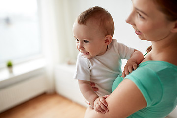 Image showing happy young mother with little baby at home