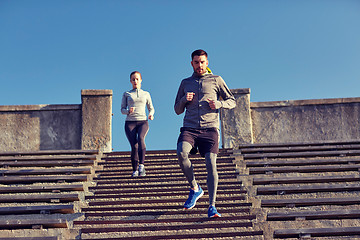 Image showing couple running downstairs in city