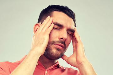 Image showing unhappy man suffering from head ache