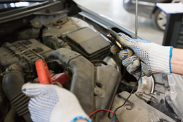 Image showing auto mechanic man with cleats charging battery