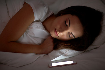 Image showing woman with smartphone sleeping in bed at night