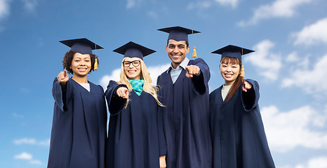 Image showing happy students or bachelors pointing finger at you