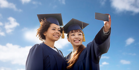 Image showing students taking selfie by smartphone over blue sky