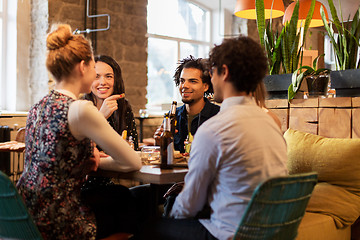 Image showing happy friends eating and drinking at bar or cafe