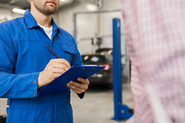 Image showing auto mechanic with clipboard and man at car shop