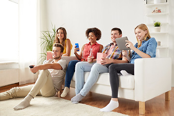 Image showing friends with gadgets and beer watching tv at home