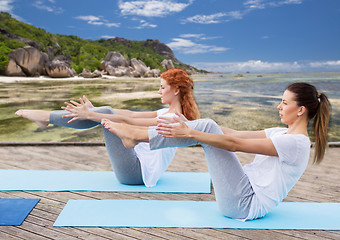 Image showing women making yoga in half-boat pose outdoors