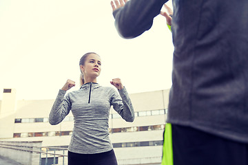 Image showing woman with trainer working out self defense strike