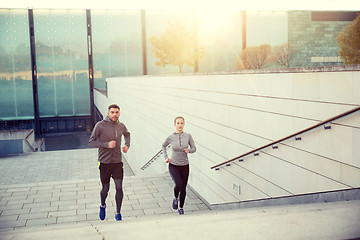 Image showing happy couple running upstairs on city stairs