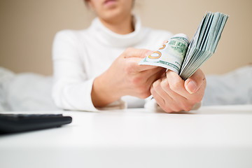 Image showing business, finance, saving, banking and people concept - close up of woman hands counting us dollar money