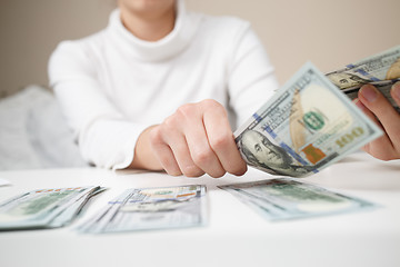 Image showing Close up of woman with calculator counting money