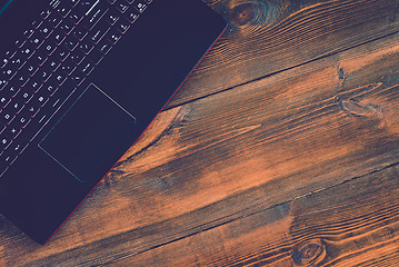 Image showing Workspace with laptop on hard wood desk