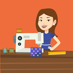 Image showing Seamstress using sewing machine at workshop.