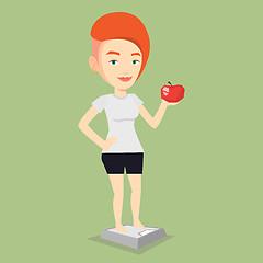 Image showing Woman standing on scale and holding apple in hand.