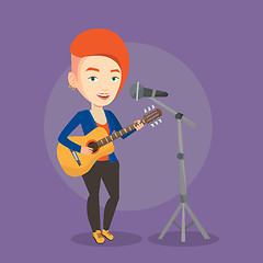 Image showing Woman singing in microphone and playing guitar.