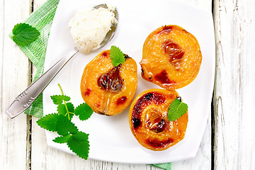 Image showing Quince baked with ice-cream and mint in plate on board top