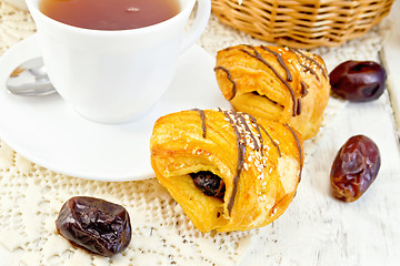 Image showing Cookies with dates and tea in white cup on light board