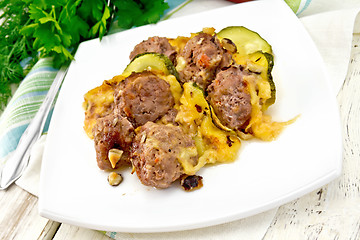 Image showing Meatballs with zucchini and cheese in plate on board