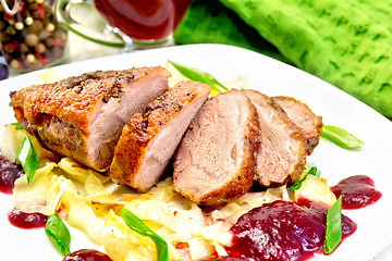 Image showing Duck breast with plum sauce and cabbage in plate on light board