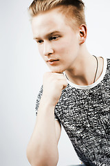 Image showing young handsome teenage hipster guy posing emotional, happy smiling against white background isolated, lifestyle people concept closeup