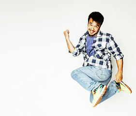 Image showing young pretty asian man jumping cheerful against white background