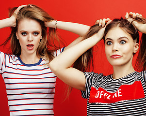 Image showing two best friends teenage girls together having fun, posing emotional on red background, besties happy smiling, lifestyle people concept close up