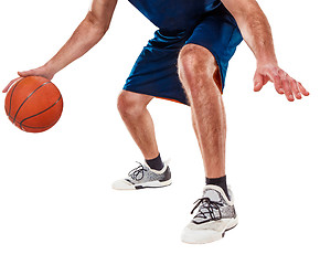 Image showing The legs of a basketball player with ball