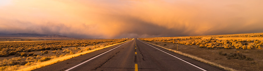Image showing Storm Brews over Two Lane Highway At Sunset