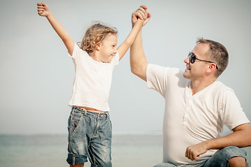 Image showing Father and son playing on the beach at the day time.