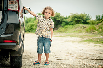 Image showing little boy standing near the car