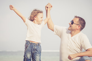 Image showing Father and son playing on the beach at the day time.