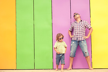 Image showing Father and son relaxing near the house at the day time.