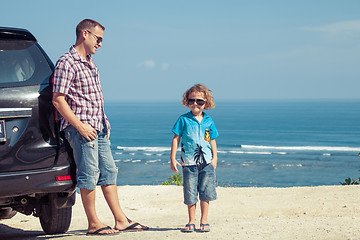 Image showing Father and son playing on the beach at the day time.