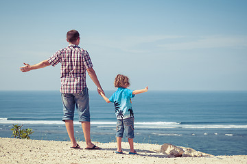 Image showing Father and son playing on the beach at the day time.